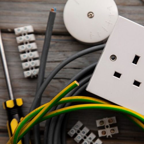 Electrical tools and equipment on a wooden background